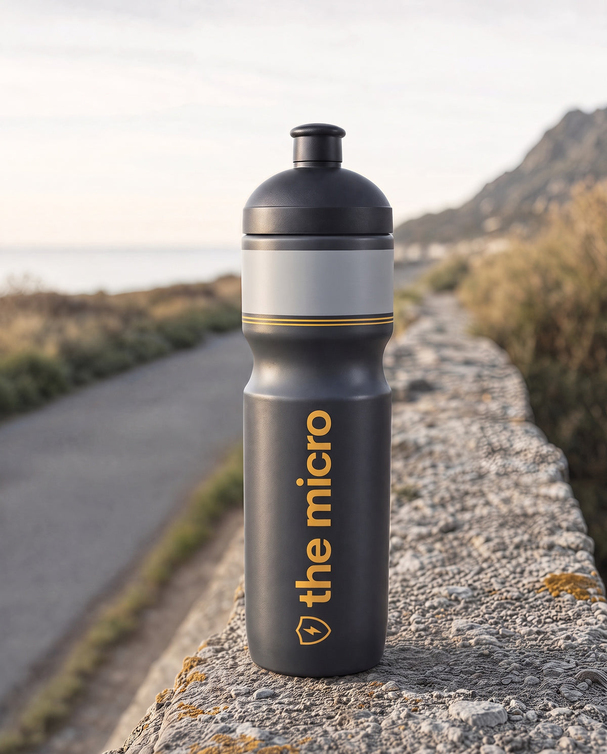 The Micro race bottle on a stone wall beside a coastal road