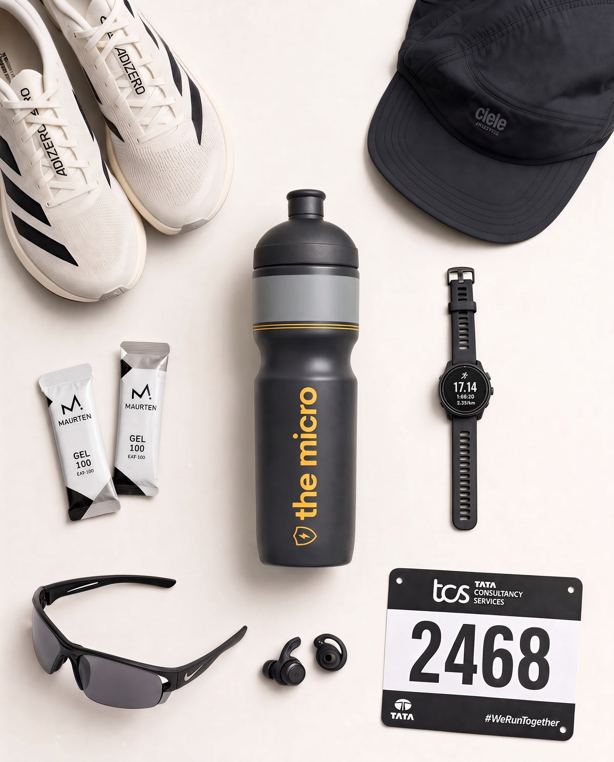 The Micro race bottle in a flat lay with running shoes, cap, watch and race bib