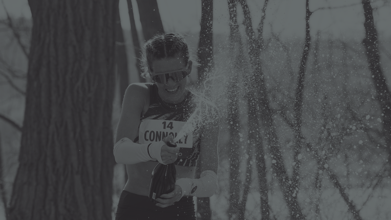 Woman celebrates marathon finish by opening a bottle of champagne