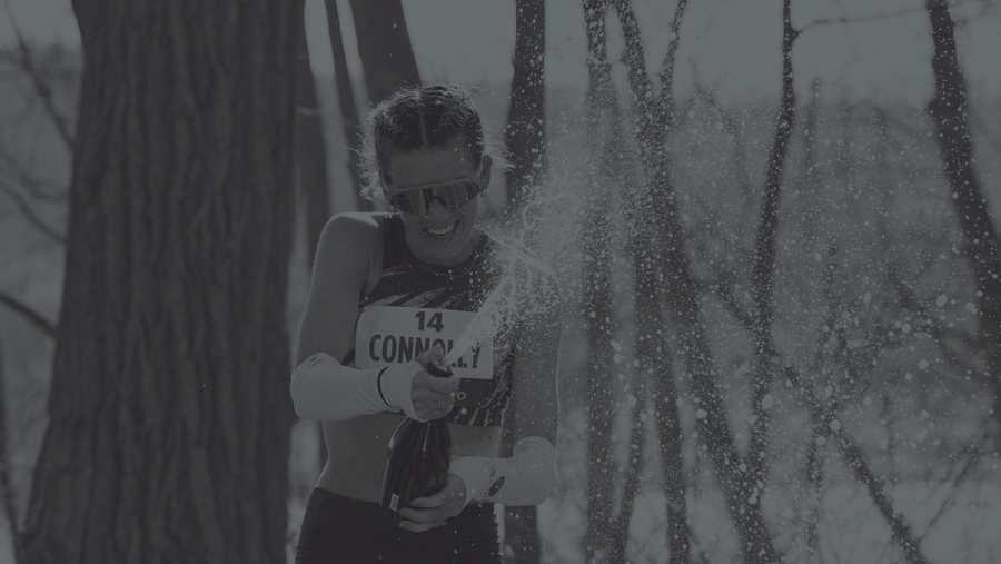 Woman celebrates marathon finish by opening a bottle of champagne
