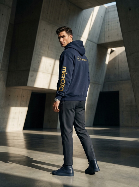 Man wearing a navy hoodie with yellow text in an architectural setting