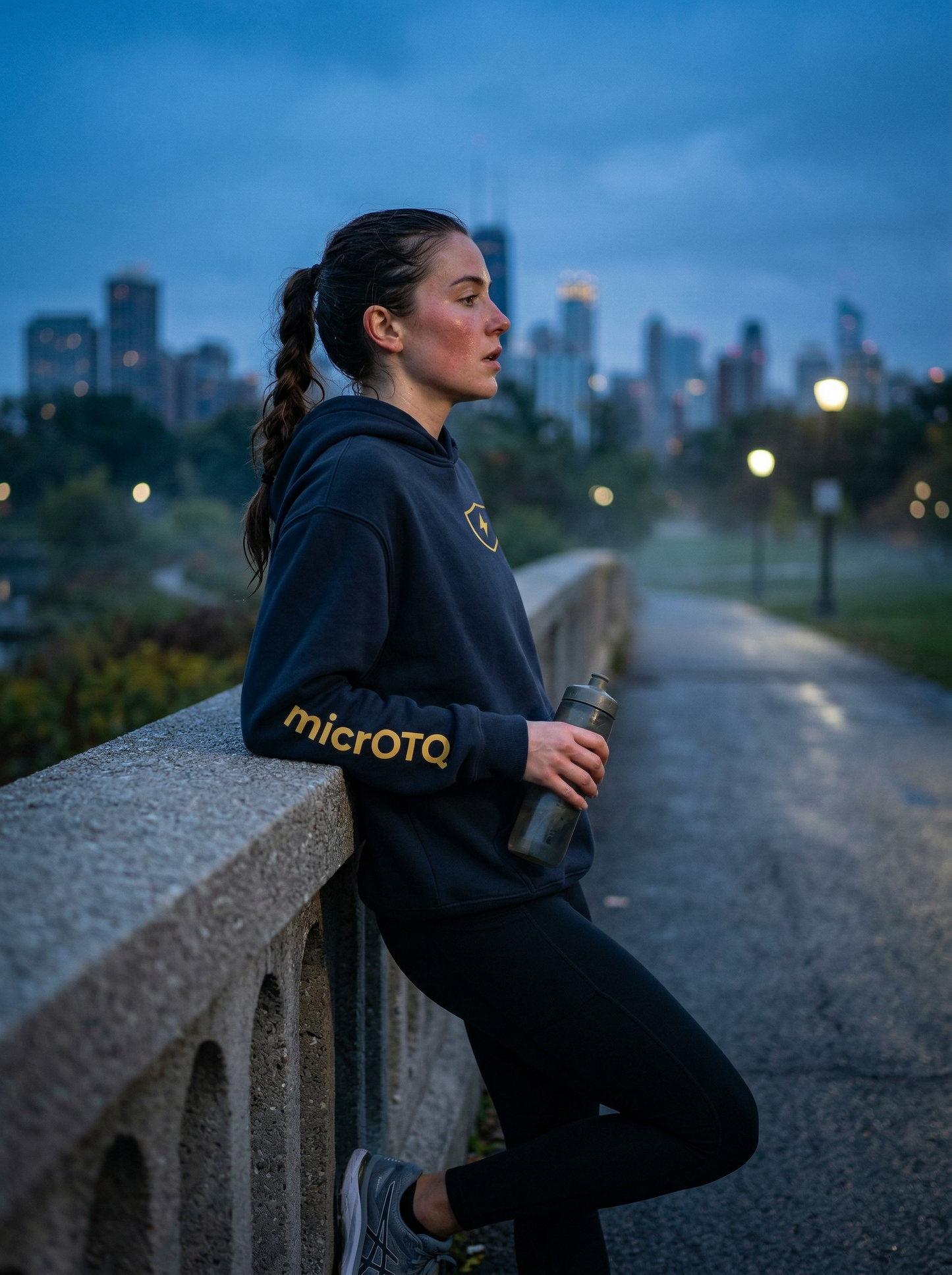 Runner leaning on a railing with a cityscape in the background